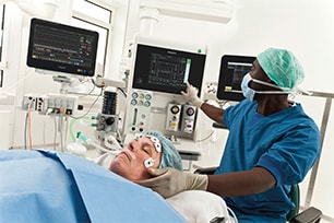 Anaesthesiologist using ICCA clinical information system during surgery.