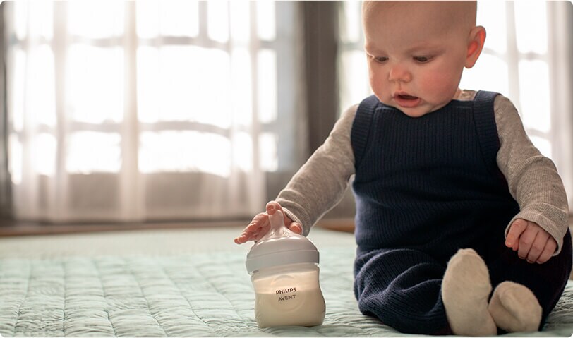 Baby getting ready to feed from a bottle