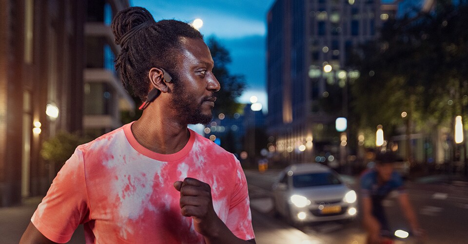 Športnik uporablja slušalke s kostnim prevodom na prometni ulici