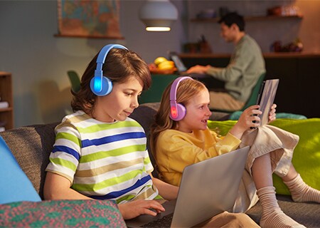 Otroka uporabljata funkcijo barvitih svetlečih ploščic naušesnih slušalk Philips