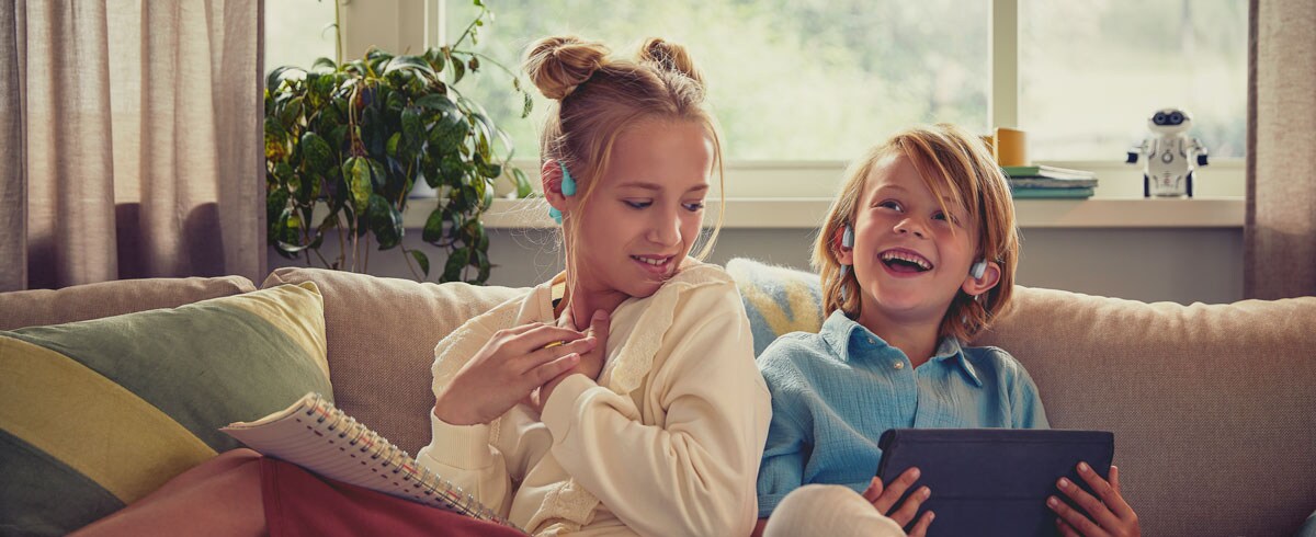 Otroci uživajo v videu z otroškimi obušesnimi slušalkami Philips