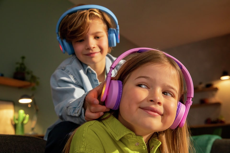 Sorojenca med igro uporabljata naušesne otroške slušalke