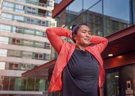 Ženska uporablja brezžične slušalke Philips A5508 na prostem