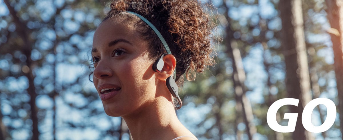 Bližinska fotografija ženske, ki nosi kostnoprevodne športne slušalke