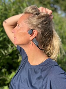 Ženska nosi kostnoprevodne slušalke Bluetooth Philips