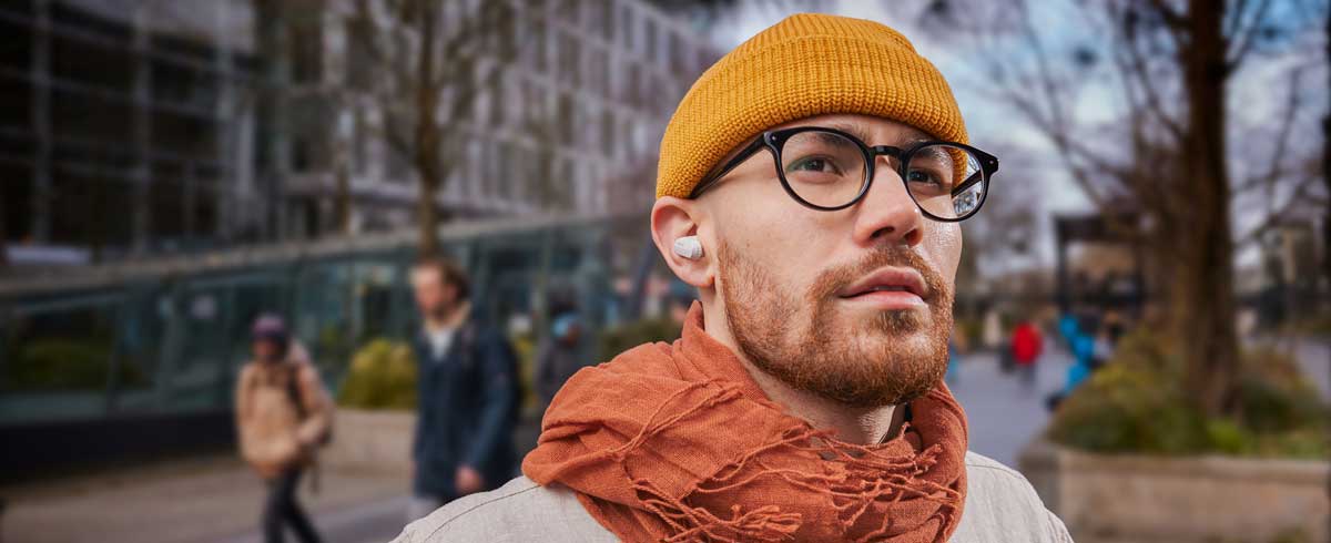 Fotografija moškega od blizu, ki nosi prave brezžične slušalke