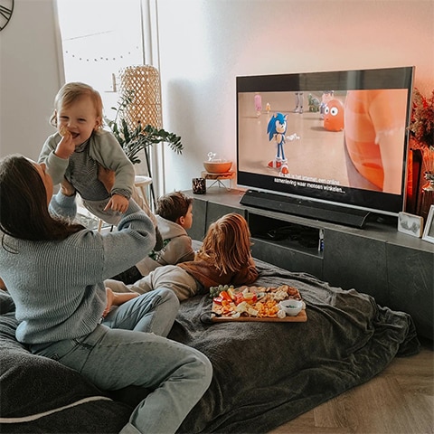 Družina gleda televizijo Ambilight